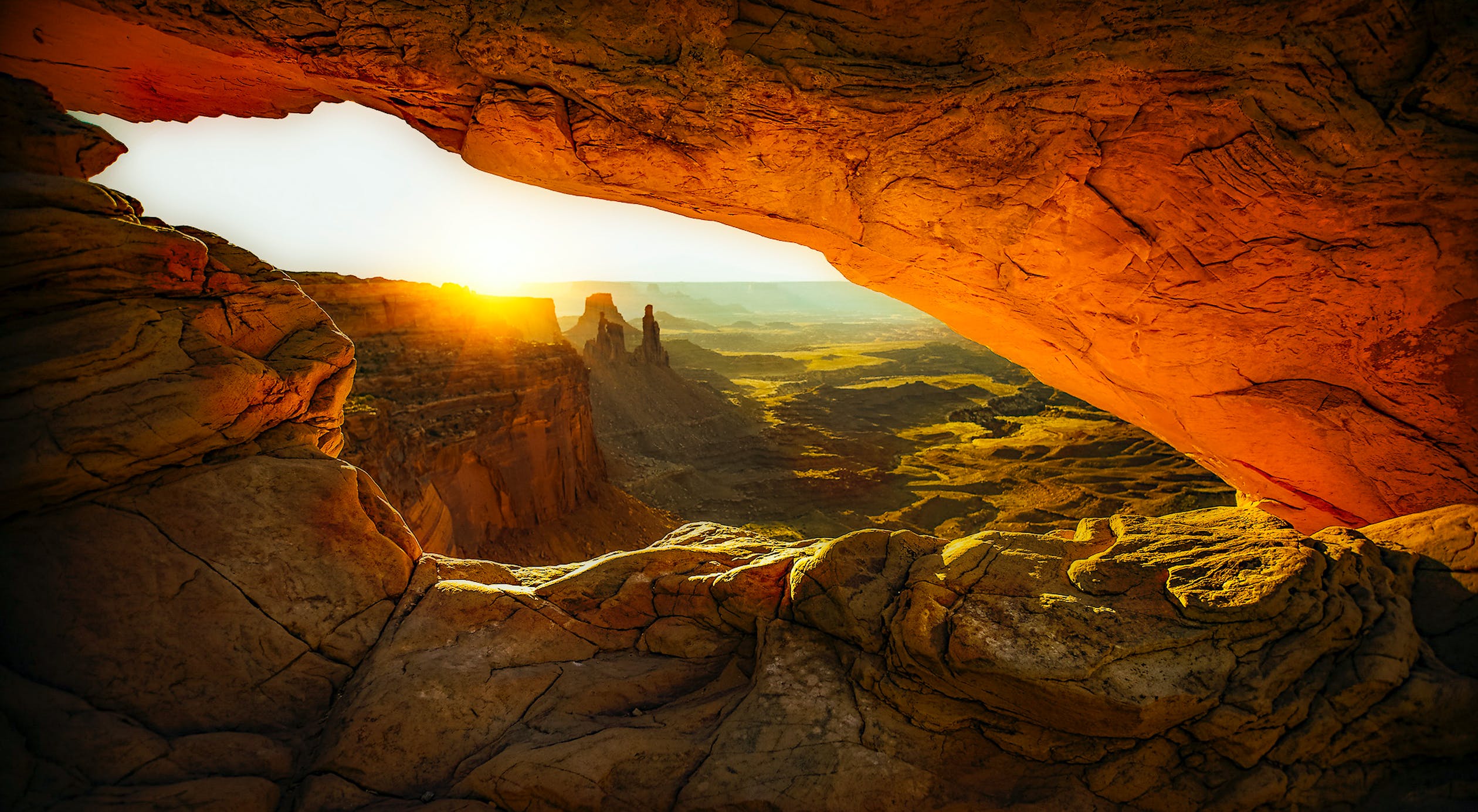 Background image of a cave with the sun in the horizon
